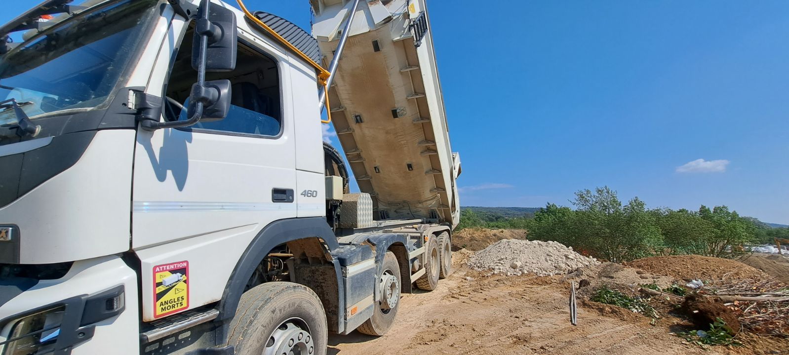 Camion benne TP en chantier déchargeant des gravats